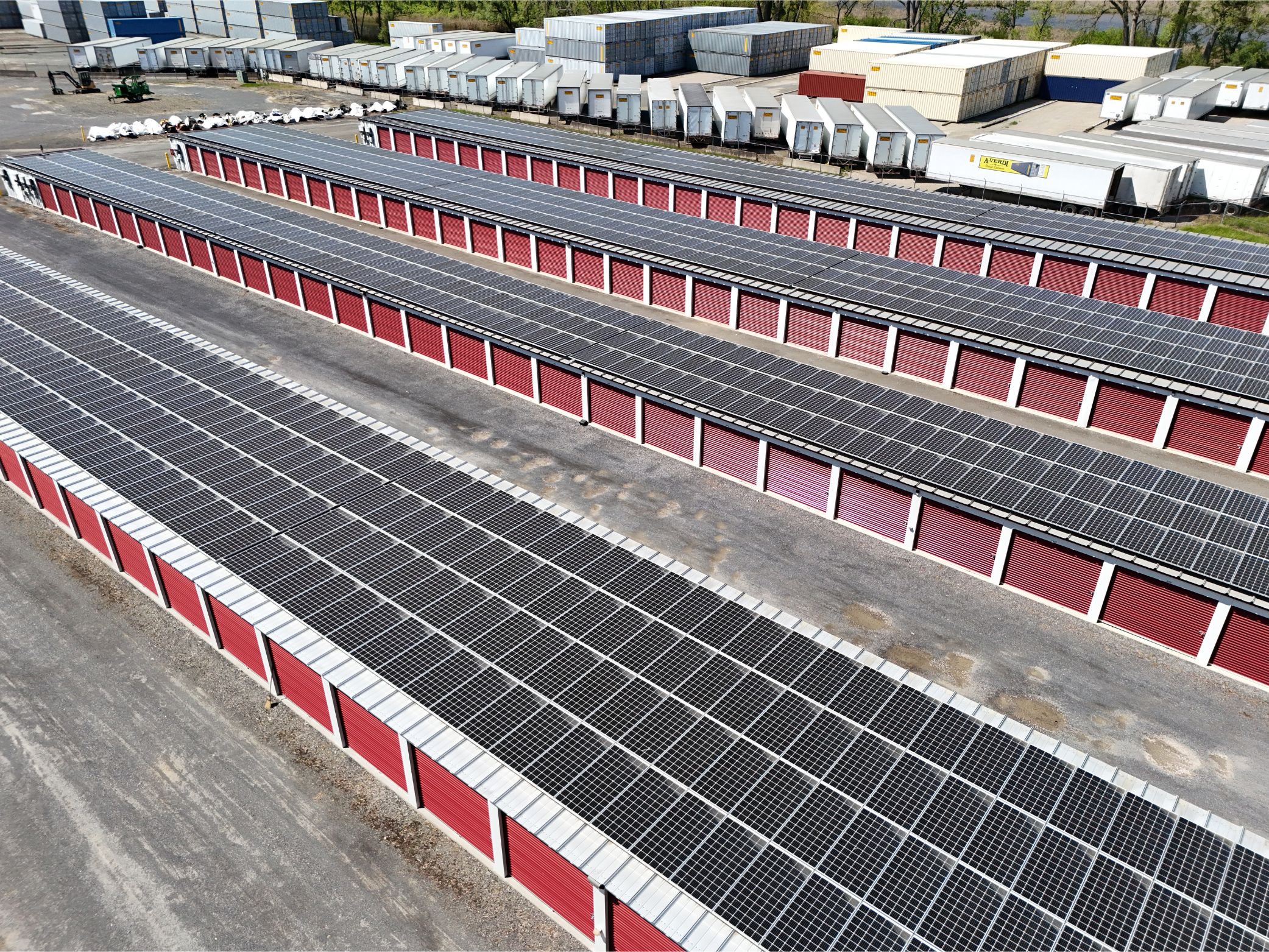 Aerial view of A-Verdi Self Storage units with red doors and solar panels installed across the rooftops.